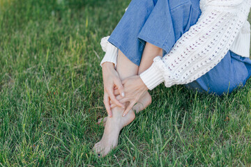 Beautiful legs of a young woman barefoot on the fresh green grass. Spring time in the park, nature lover, relax