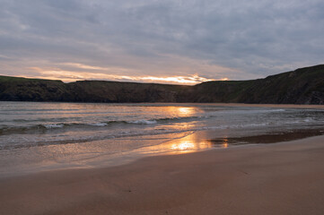 The beach is empty and the sun is setting
