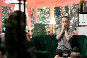 Troubled teen expressing her anxiety and mental health issues during a therapy session with psychologist, low confidence and internal frustration. Scared confused girl with personal troubles.