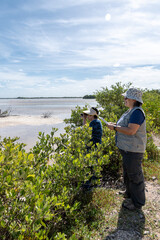 Two women birdwatch with binoculars in a wetland. Yucatán, Mexico.