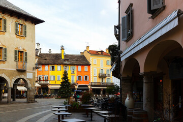 Fototapeta premium View of empty Piazza del Mercato in historical center of small Italian town of Domodossola with decorated Christmas tree on winter day