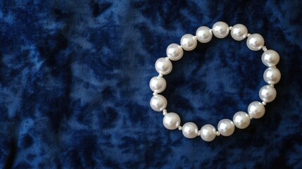 Pearl necklace in S-shape on navy blue velvet-textured background, high contrast elegance, no people