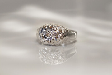 Stunning handmade silver ring featuring rough surface and tiny diamonds, perfect for any occasion.