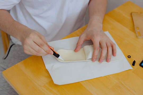 A young man repairs shoes at home.