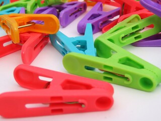 Closeup of multicolored plastic clothes peg on white background.
