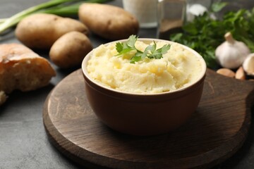 Delicious mashed potato with parsley served on black table, closeup