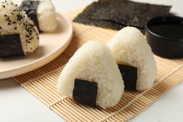 Rice balls (onigiri) on light table, closeup. Traditional Japanese dish