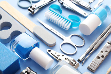 Set of different manicure tools on light blue background, closeup
