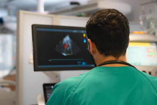 Doctor examining heart scan on computer monitor in operating room