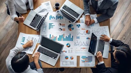 Overhead shot business meeting four people analyzing charts , graphs wooden table. Laptops are open, , coffee cup is visible. The focus is collaborative data analysis business strategy. - Powered by Adobe