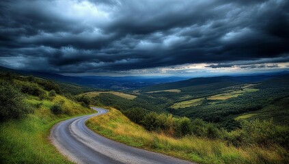 Winding road through valley, ominous clouds overhead