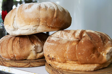 Three round Italian style breads stacked on a counter