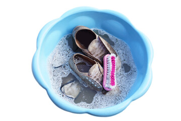 Dirty white sneakers, shoes and brush soak in detergent water to clean and scrub, isolated on white...