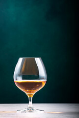 French cognac Superior in snifter glass on dark green background