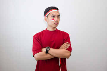Man with Angry Expression Wearing Red Shirt and Flag Accessories to Celebrate Indonesian Independence Day.