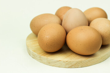 Chicken eggs served on a wooden cutting board and isolated on a white background. Close up.