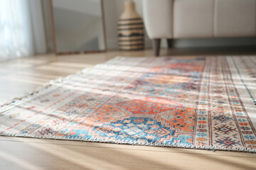 Colorful patterned rug on wooden floor in a sunlit living space