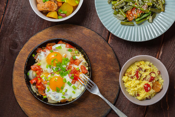 Jewish food tzimmes, chelnt, shakshuka for the holiday next to a fork
