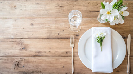 beautifully arranged dining table featuring white napkin, fork, and glass of water, complemented by fresh flowers
