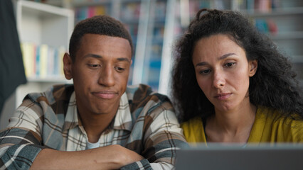 Unhappy Indian Hispanic woman African American man classmates students girl guy library university...