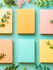 Colorful notebooks with green leaves on backdrop.