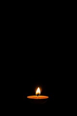 Single candle flame against black background
