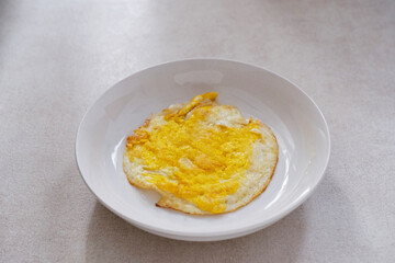 Fried egg on white plate for breakfast
