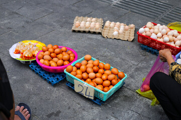 Fresh eggs displayed in colorful baskets for sale at a local market in Vietnam.