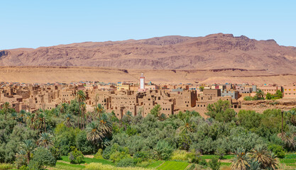 Old kasbah in Tinerhir, typical Moroccan town beside an oasis in Dades Valley - Ancient Berber village, lush green oasis in valley surrounded by the Atlas - Mountains - Tinghir, Morocco