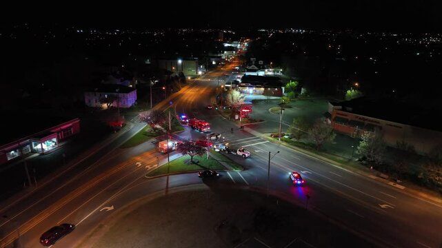 Car crash accident one junction of freeway ib American suburb. Night scene with flashing lights of police and ambulance. Aerial view. Dangerous scene in USA. orbit shot.