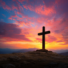 A wooden cross stands on rocky hilltop against vibrant sunset sky, symbolizing hope and serenity