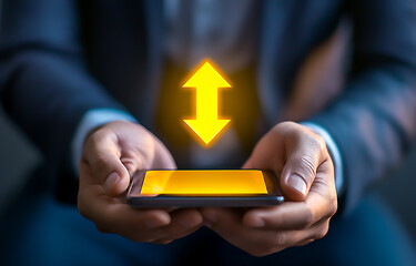 A businessman using a mobile phone with a yellow, glowing e-commerce shopping icon on the screen and an arrow pointing down, representing the online market concept