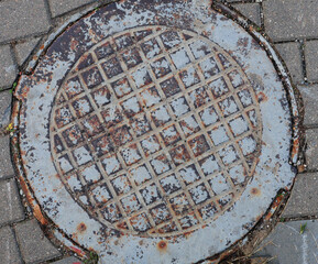 A metal sewer manhole in the road.