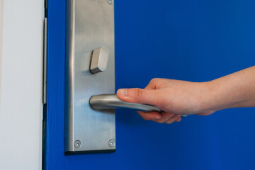 Close up hand of woman open door in hotel. Security systems and protection concept.