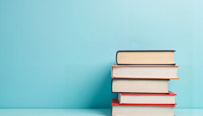 Stack of books on soft blue background, knowledge and learning