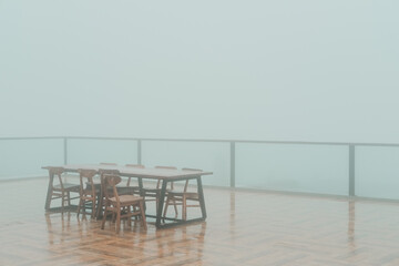 Table and chairs on a foggy balcony, providing a serene setting for lifestyle or interior design...