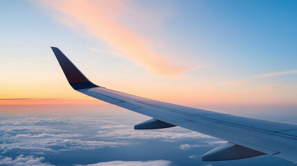 Obraz premium Airplane wing against vibrant sunset sky, showcasing beauty of flight and travel. Clouds below create serene atmosphere