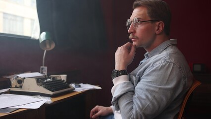 Male novelist in smoky vintage office, cinematic soft-focus capturing intense writing session at...