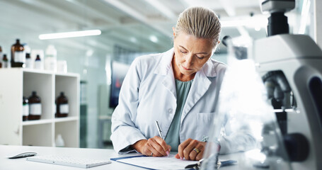 Woman, scientist and writing with documents for medical results or discovery at laboratory. Mature...
