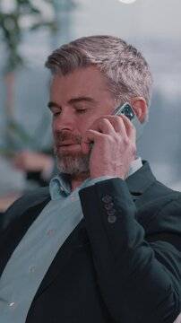 A suited man converses on a cell phone in various corporate settings