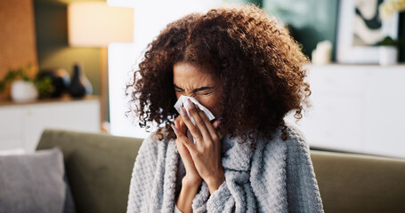 Sneeze, sick and blowing nose with woman on sofa for medical recovery, illness and flu season. Disease, fatigue and fever with female person in living room at home for virus outbreak and cold