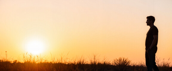 Strong silhouette of man standing at sunset, inspiring perspective
