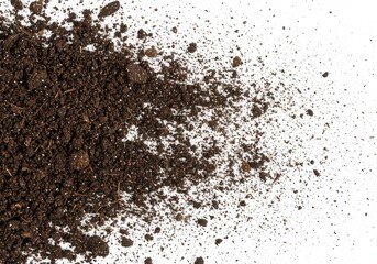 A scattering of dark brown soil or dirt particles on a plain white surface with varying density spread