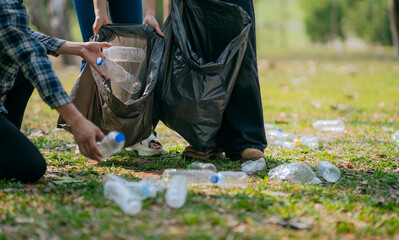 Volunteers collect plastic bottles, put trash in black trash bags to clean the park, avoid...