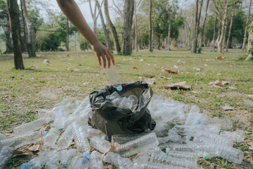 Volunteers collect plastic bottles, put trash in black trash bags to clean the park, avoid...
