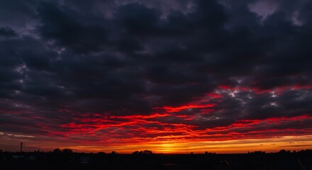 Fototapeta premium Fiery sunset dramatically paints dark clouds red. AI Generated