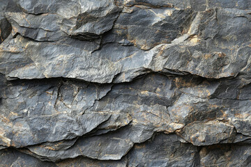 Close-up view of layered, dark grey rocks with rough texture and natural cracks.