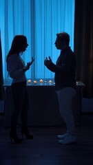 Silhouette of Couple Arguing in Dimly Lit Room with Candles
