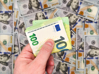 Male white left hand holding 100 euro bill showing that one euro bill is now stronger than...