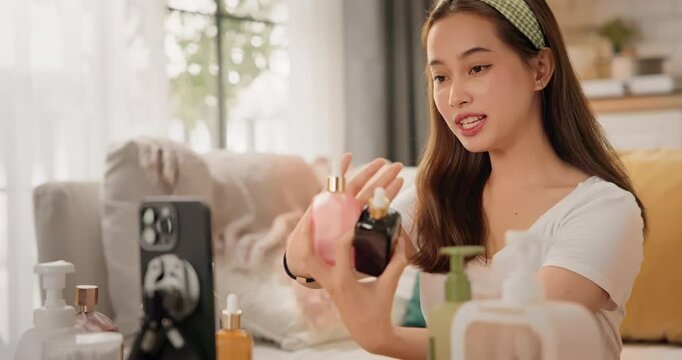 Asian woman beauty influencer, content creator filming skincare product review on smartphone at home. Gen Z lifestyle social media trends. digital marketing, promotions, cosmetic branding vlogs.